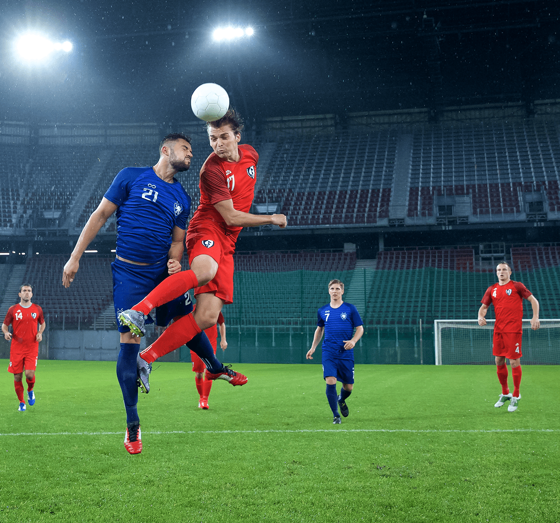 Soccer players competing for a header.