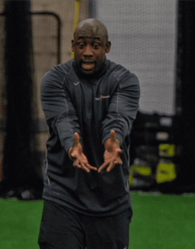 Man gesturing passionately during indoor training session.