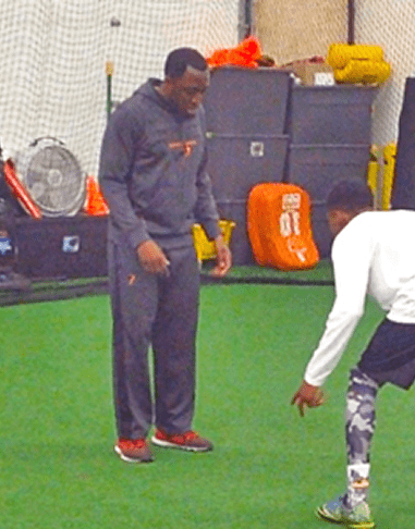 Two people training on indoor field.